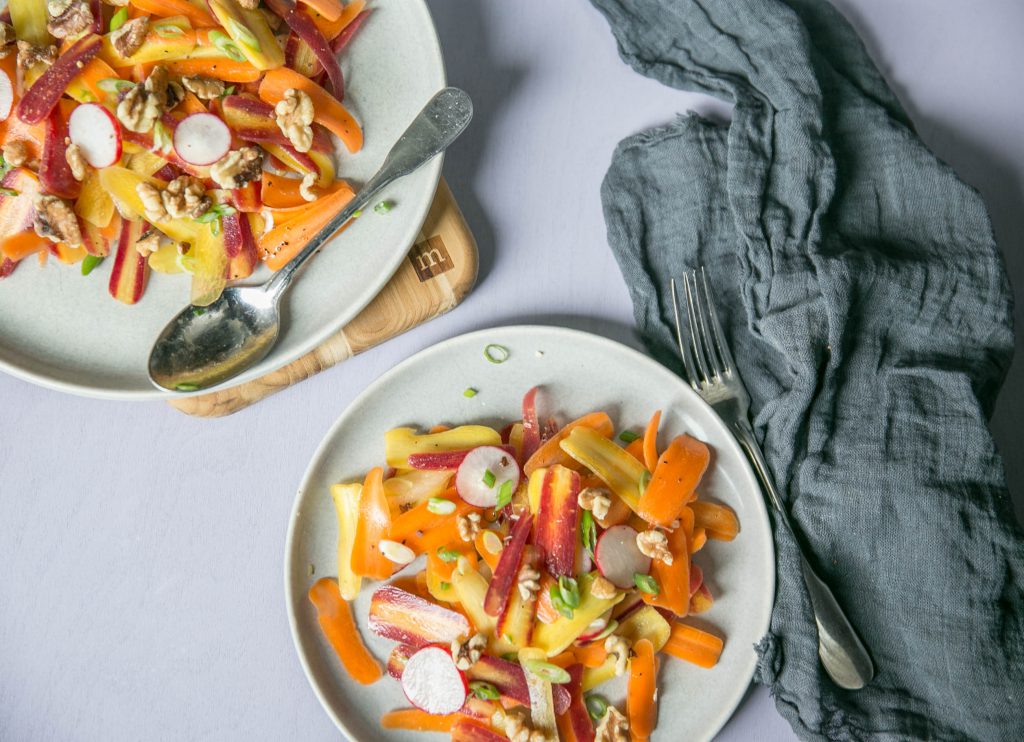 Overhead shot of two plates of carrot scallion coriander salad